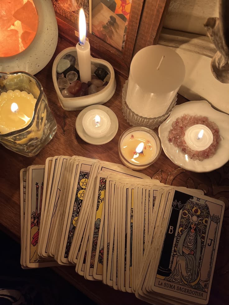 Cartas de tarô abertas entre velas e cristais